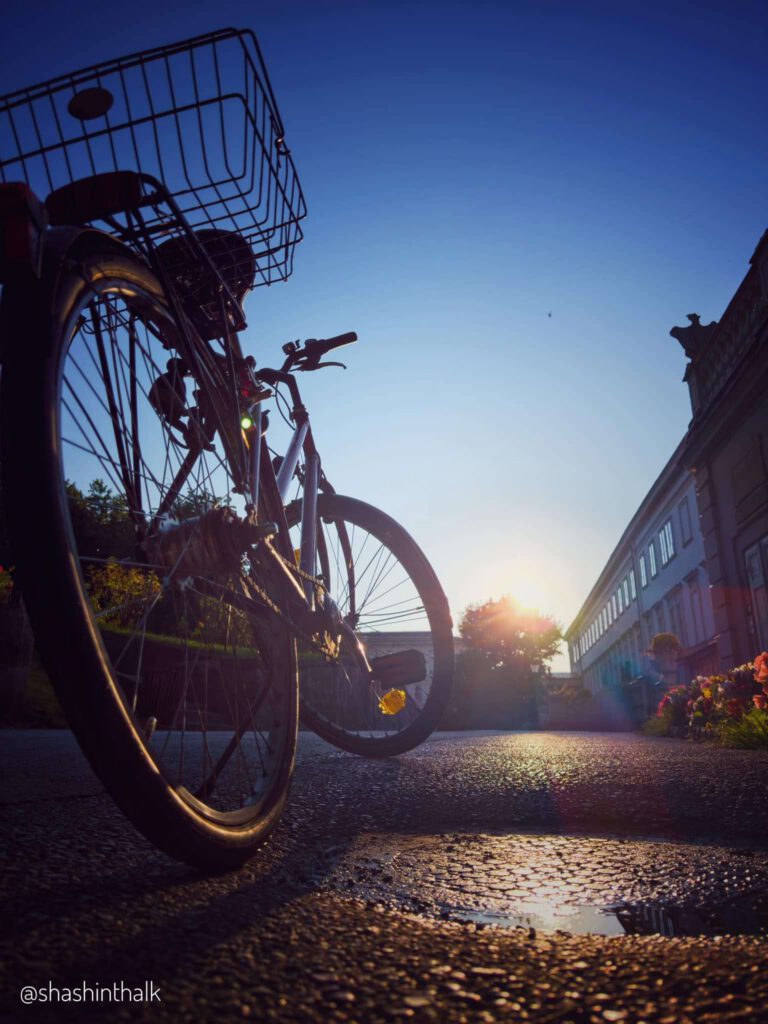 Bicycle with a basket at sunset, shot from street level
