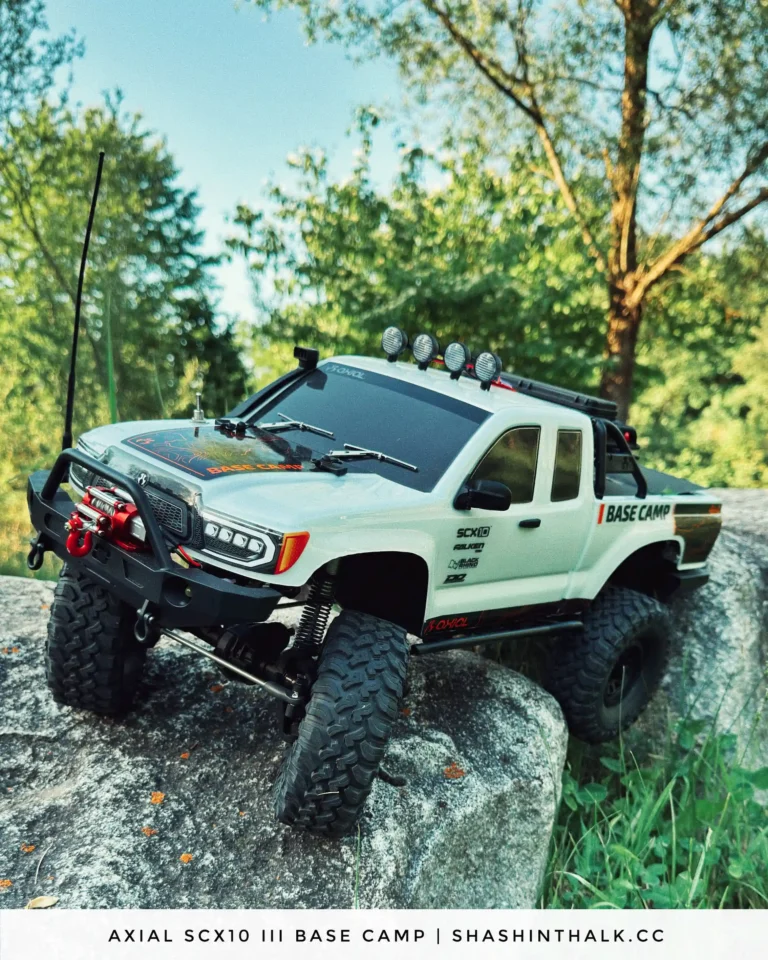 Axial SCX10 III Base Camp RC crawler on a rock under trees